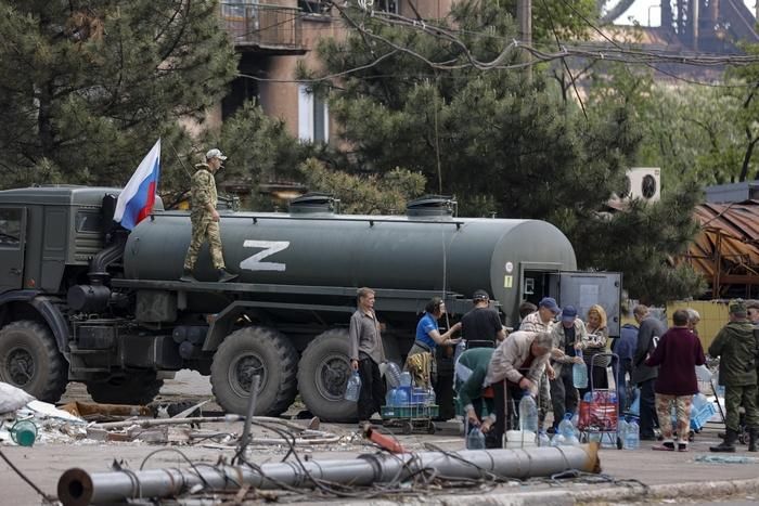 Цивилни украинци се редят на опашка за чиста вода, доставяна от руските окупационни войски в Мариупол. Снимка АП / БТА